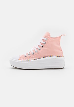 Høj sko i pink lærred med hvide snørebånd, tyk hvid sål og flerfarvet stribe over sålen.