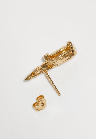 Boucle d'oreille dorée présentant un design sculptural en forme de main avec une tige droite et un fermoir sécurisé. Texture lisse et brillante avec des détails définis.