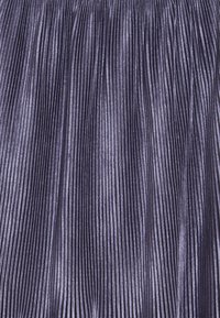 Plisovaná sukně v tmavě fialové barvě s lesklým, texturovaným povrchem. Obsahuje úzké, vertikální plisování po celé délce, čímž vytváří strukturovaný vzhled.
