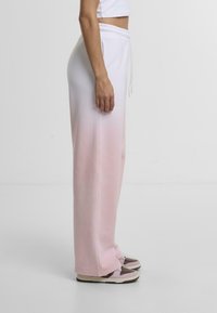 Lightweight, pink ombre sweatpants with an elastic waistband and drawstring. Features a relaxed fit and smooth fabric texture.