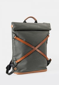 Rolltop-Rucksack aus dunkelgrünem Canvas mit braunen Lederakzenten. Verfügt über verstellbare Träger und einen gummiartigen Boden für zusätzliche Haltbarkeit.