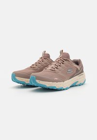 Baskets de sport brun clair avec tige en mesh, semelle intermédiaire beige et semelle extérieure en caoutchouc bleue. Inclut des lacets contrastés et des accents de logo.