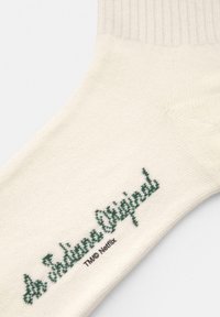 Skarpetki bawełniane w kolorze kremowym, z fakturą ribbed, z zielonym napisem "As Originals" oraz małym detalem z logo.