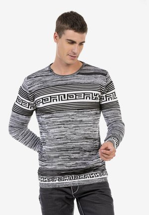 Langärmliger Pullover mit schwarz-weißem Streifenmuster und geometrischem Design auf der Brust. Hergestellt aus strukturiertem Stoff, mit rundem Halsausschnitt.