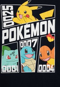 Černé tričko s obrázky kreslených Pokémonů: Pikachu (žlutý) nahoře, Bulbasaur (zelený), Squirtle (modrý), Charmander (oranžový) dole s číselnými kódy.