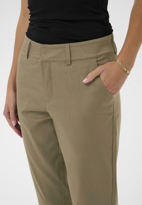 Khaki bukser med en klassisk pasform, sidelommer og en glat tekstur. Livremmen har bæltestropper for ekstra justerbarhed.