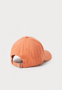 Casquette de baseball en coton orange avec une visière courbée, une sangle ajustable à l'arrière et des trous d'aération. Texture de tissu lisse.