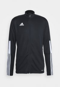 Zwarte sportjack met een rits aan de voorkant, hoge kraag, witte accenten en drie witte strepen langs de mouwen. Gemaakt van glad, rekbaar materiaal.