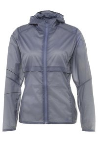 Veste légère, résistante à l'eau, de couleur bleu marine. Dotée d'une fermeture éclair complète, d'une capuche et d'accents élastiques sur les manches. Tissu lisse et texturé.