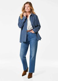 Blue textured button-up shirt, white patterned shirt beneath, high-waisted blue jeans, and brown heeled ankle boots. Casual outfit.