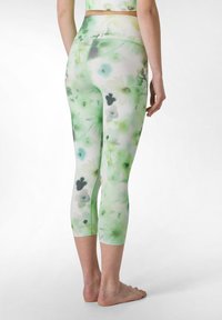 Leggings capri con fantasia floreale nei toni del verde e bianco, realizzati in tessuto elasticizzato. Presentano una vita alta e un design aderente.