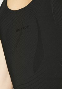 Canottiera atletica nera con un design testurizzato e linee rigate, con il testo "ONLY PLAY" in finitura opaca sul davanti.