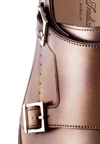 Metalen bronzen leren schoen met een ronde neus, voorzien van een zilveren gesp en stikdetails aan de zijkant.