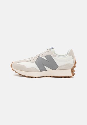 Retro running shoe in white and grey, featuring a suede and leather upper, a textured grey "N" logo, and a rubber outsole with traction.