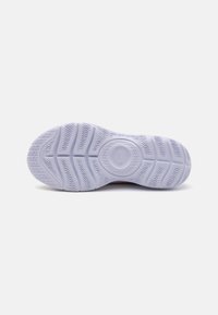 White rubber shoe sole with textured tread patterns and a circular logo detail. Smooth, flexible material with pronounced grooves for traction.