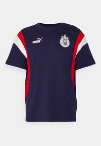 Navy blue cotton T-shirt with white and red side panels. Features Puma logo on the chest and a team emblem on the left. Short sleeves, crew neckline.