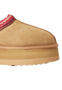 Pantofole in suede color beige con un'accattivante cucitura rossa e beige nella parte superiore. Suola spessa e testurizzata con un bordo seghettato per una migliore presa. Marchio discreto visibile.