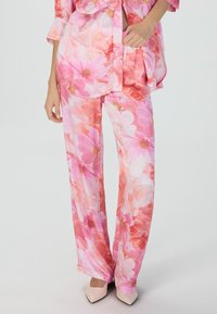 Blumenmuster-Loungewear-Set mit pinken und orangefarbenen Farbtönen, leichtem Stoff, locker sitzendem Oberteil und Hose mit elastischem Bund.