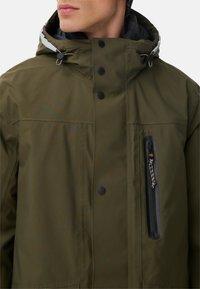 Olivgrüne isolierte Jacke mit einer Reißverschlusstasche auf der Brust, Druckknöpfen, verstellbarem Kapuze und einer glatten, matten Oberfläche.
