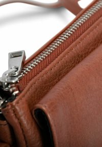 Portafoglio in pelle marrone con una texture liscia, caratterizzato da una cerniera argentata, cuciture a contrasto e un compartimento aperto per una maggiore accessibilità.