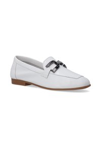 Witte leren loafers met een lage bruine hak, voorzien van een zwarte dubbele gespaccent op de bovenzijde en stikseldetails langs de randen.