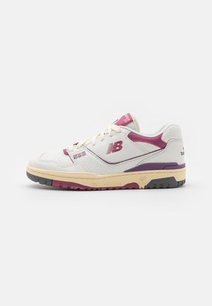 Zapatilla New Balance 550 blanca y burdeos con suela beige, logo lateral y diseño con cordones sobre un fondo blanco liso.