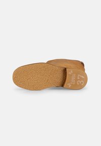 Semelle de botte en cuir marron avec une surface texturée, présentant un design léger et flexible, et le numéro de taille 37 estampé sur le talon.