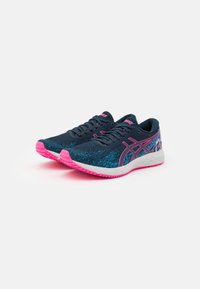 Des chaussures de course avec une tige en maille texturée bleu marine, des accents roses sur la semelle et le logo, et un design élégant et léger adapté à une utilisation athlétique.