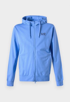 Blaues Zip-Hoodie aus weichem Material, mit Kordelzugkapuze, Fronttaschen und einem kleinen schwarzen Logo auf der Brust.