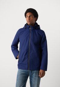 Veste imperméable bleu marine avec capuche, dotée d'une fermeture éclair à l'avant, de deux poches latérales et de poignets élastiques pour un ajustement sécurisé.