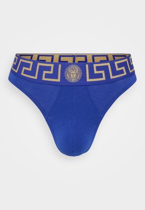 Bañadores de algodón azules con una cinturilla con un patrón dorado que presenta un emblema de Medusa y un diseño de clave griega. Textura suave y forma ajustada.