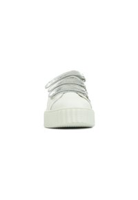 Baskets blanches avec une semelle épaisse à texture, dotées de lacets élastiques métalliques argentés et d'un dessus lisse ressemblant à du cuir. Design minimaliste.