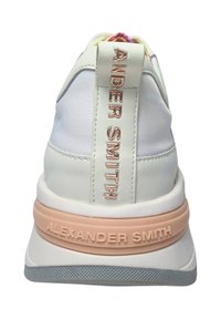 Weißer Sneaker mit Obermaterial aus Leder und Stoff, ausgestattet mit einer pinken Gummisohle, geprägtem Branding an der Ferse und einem bunten Schnürsenkeldetail.