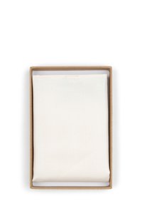 Witte canvas in een bruine kartonnen doos. Het canvas heeft een gestructureerd oppervlak, met zichtbare stiksel rond de randen.