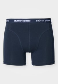 Sötétkék boxer alsó, puha anyagból készült, egyszínű, kontrasztos varrással és márkás elasztikus derékpánttal.