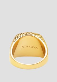 Guld metal ring med en glat bande og en bladmønstret accent på toppen. Graveret med brandnavnet "NIALAYA" indvendigt.
