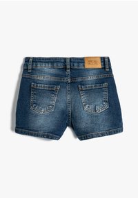 Jeansshorts för barn, med en mörk tvätt, femfickorsdesign, synlig sömnad och en tan läderetikett på den bakre midjebandet.