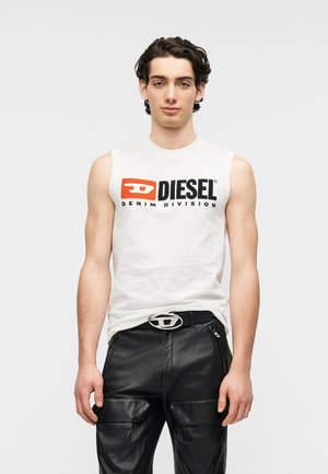 Brezrokavnik iz belega bombaža z logotipom "DIESEL" v črni in rdeči barvi, kombiniran s črnimi usnjenimi hlačami in srebrno zaponko na pasu.