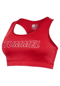 Czerwony sportowy biustonosz z wycięciem typu racerback, wyraźnym białym logo "HUMMEL" na przodzie oraz metką z rozmiarem wewnątrz dekoltu.