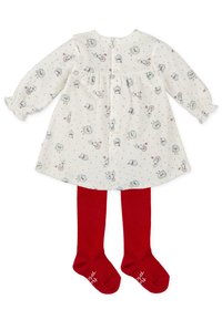 Vestido blanco con patrones coloridos que presentan animales y juguetes, de mangas largas y puños con volantes. Combinado con medias rojas.