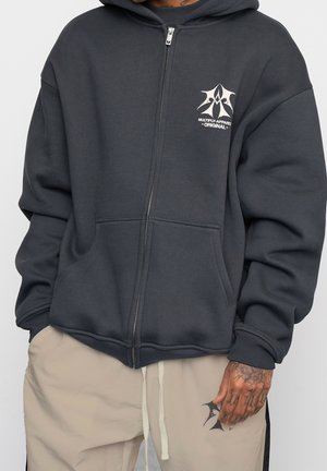 Graue Sweatjacke mit Reißverschluss aus weichem Stoff, mit einer Fronttasche, gerippten Bündchen und einem Logo-Print auf der linken Brust.