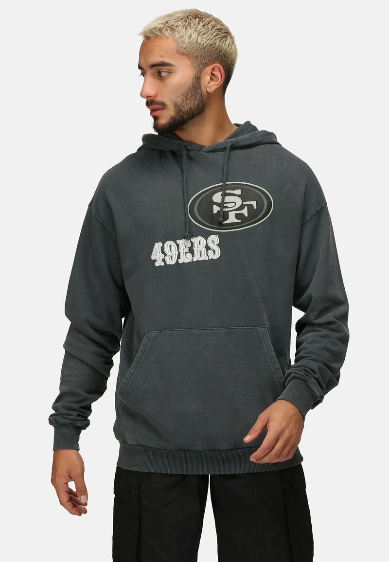 Sudadera de color gris oscuro con un bolsillo tipo canguro en la parte frontal, con un logo circular y el texto "49ERS" en blanco. Fabricada con un material suave.