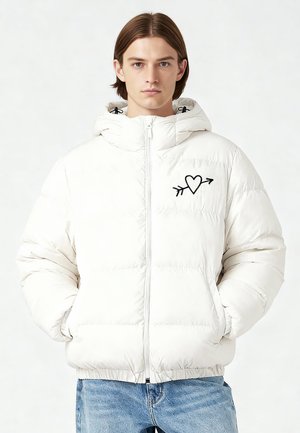 Giacca imbottita bianca con cerniera, dotata di cappuccio e polsini elasticizzati. Ricamo nero a forma di cuore e freccia sul petto.