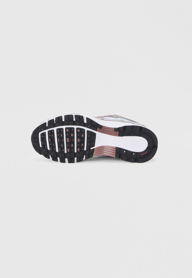 Semelle extérieure de chaussure de course Nike, en caoutchouc noir avec motifs d'adhérence, semelle intermédiaire blanche et accents roses, avec un design amortissant pour le confort.