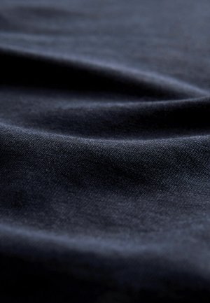 Tumesinine kangas, millel on sile ja kergelt tekstureeritud pind, pehmete voldikute ja õrna läikega, rõhutades sügavust ja liikumist.