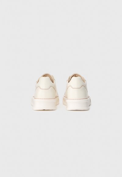 Sneakers bianchi in pelle con forma arrotondata, dettagli di cucitura minimi e suola imbottita per il comfort. Senza lacci o hardware visibile.