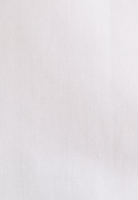 Gros plan d’un tissu tissé gris clair avec une texture subtile et un petit motif de tissage serré.