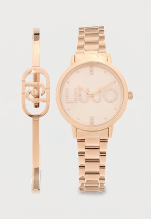 Roségoldene Armbanduhr mit kristallbesetztem "LIU JO"-Logo und passendem Armband aus Roségold mit geometrischem Design.
