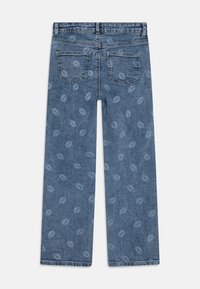 Blå denimjeans med ett upprepat läpptrycksmönster, rak bendesign och standardfickor på baksidan.