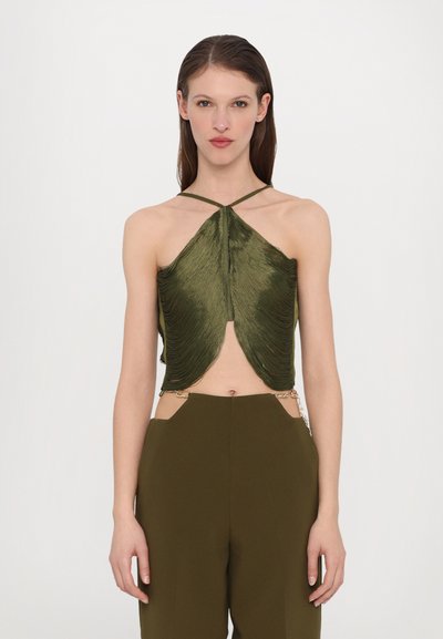 Maslinasto zeleni halter crop top s drapiranim teksturom, dubokim dekolteom i tankim trakama, u kombinaciji s odgovarajućim krojenim hlačama s bočnim izrezima.